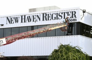 The final touches are placed on a sign at the New Haven Register's new office at 100 Gando Drive in New Haven. 
